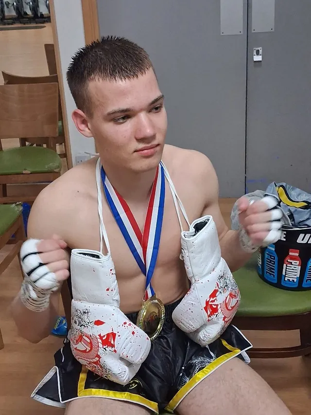 A team fighter with his medal and wrapped hands after a bout